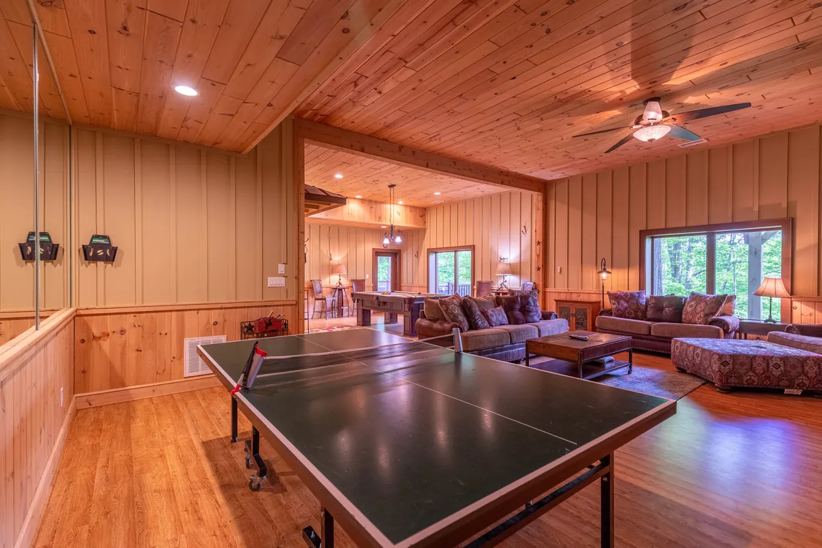 A bright, sociable room with a ping pong table and a comfortable seating area near large windows that fill the space with natural light. The atmosphere is playful and lively, perfect for friendly games or relaxing after group activities.