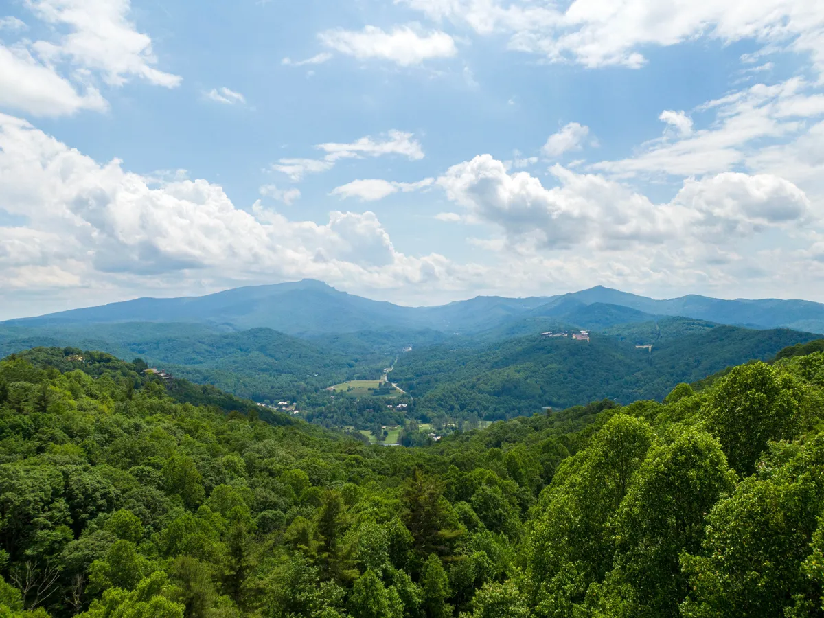 A breathtaking view of a mountain range framed by lush greenery and an open sky. The natural beauty invites exploration, hiking, and outdoor adventures, underscoring the property’s proximity to nature and the opportunities for shared experiences beyond the home itself.